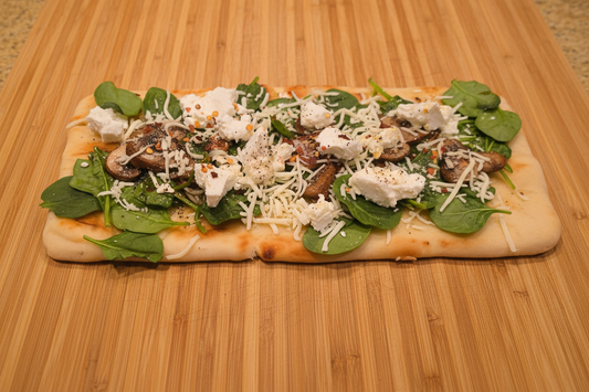 Naan pizza on bamboo cutting board - clean frame